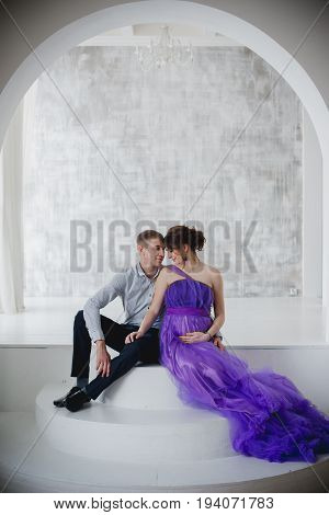 pregnant woman and man posing together in Studio, happy waiting