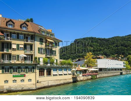 Thun, Switzerland - 21 July, 2015: buildings along the Aare river in the city of Thun in summer. Thun is a city and municipality in the administrative district of Thun in the Swiss canton of Bern, located where the Aare river flows out of Lake Thun.