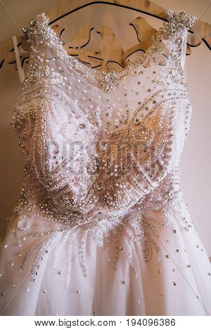 Wedding dress on hanger on a wall.