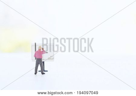 A conceptual photo with a toy engineer or other professional  at the empty drawing board with a place for your text. Focus on a figurine of a human.