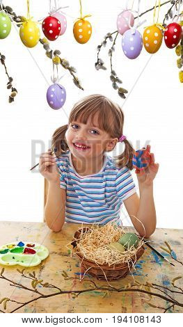 a happy little girl coloring easter eggs