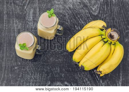 Banana Smoothies And Bananas On An Old Wooden Background