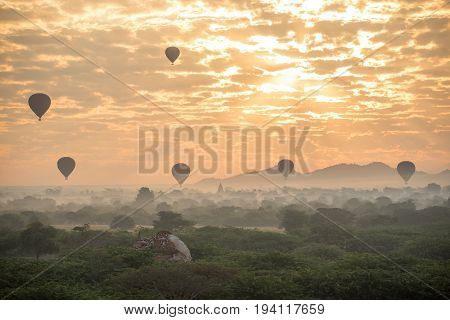 Hot air balloon over ancient pagoda in Bagan archaeological site during sunrise beautiful landscape and tourist attraction in Mandalay Region Myanmar