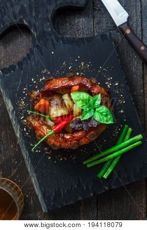 Crown roast of pork with grilled vegetables and whiskey sauce, top close view