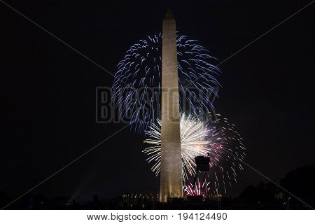 Washington DC USA - 4 July 2017: Red white and blue fireworks light the sky behind The Washington Monument on the mall in DC
