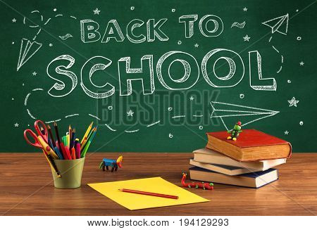Back to school concepty with writing on blackboard and desk, apple, books, items