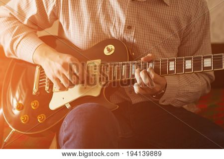 Practicing in playing guitar. Handsome young men playing guitar sunlight