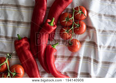 Red tomatoes and peppers on stripped cloth