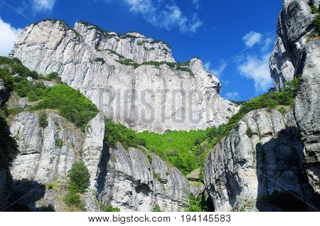 A rock cliff against a blue sky in the early morning at Fangdong Scenic Area on Yandangshan mountains located in Zhejiang province China.