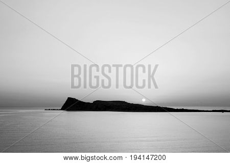 Sunrise on the beach, early morning in Kolokitha island, Crete, Greece, black and white photo