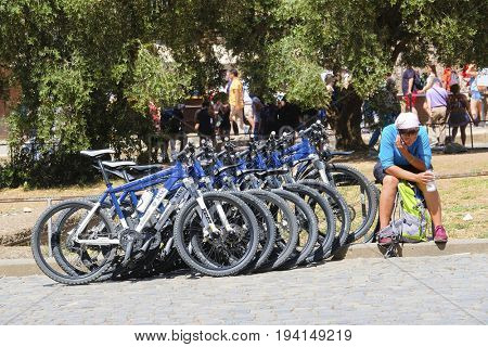 Adria, Italy - June, 7, 2017: bicycles of toyrist group parked on a square in front of Coloseum in Roma, Italy