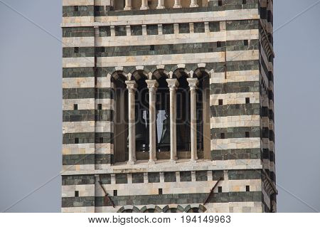 Italy Siena - December 26 2016: the close up view of the bell tower of Duomo di Siena. The view of Romanesque stylistic patterns on Campanile on December 26 2016 in Siena Tuscany Italy.