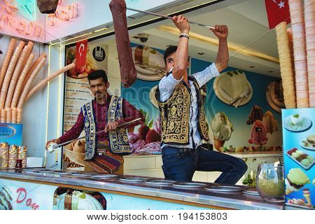 ISTANBUL TURKEY - MAY 2 2017: Young dondurma ice-cream sellers dressed in traditional Turkish costume in the street shop