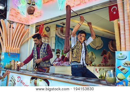 ISTANBUL TURKEY - MAY 2 2017: Young dondurma ice-cream sellers dressed in traditional Turkish costume in the street shop