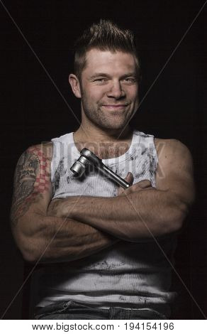 Man is smiling with a wrench an black background