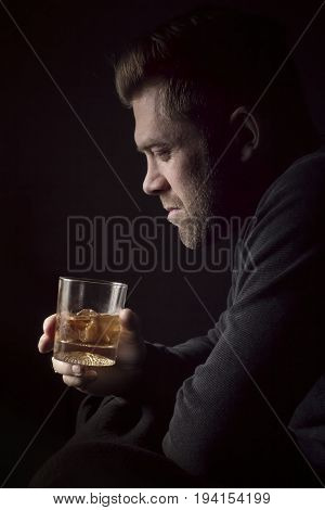 Man with a glass of whiskey with black background