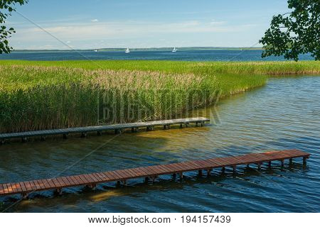Sniardwy Lake with boardwalks in foreground and some yachts in background, Mazurien Region, Poland, Europe