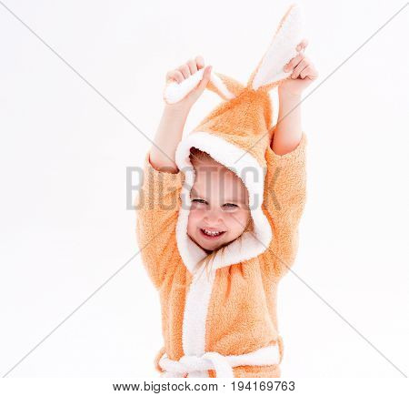 Active and playful little kid wearing peachy robes for bathing, playing with her bunny ears