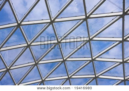 Teto transparente no edifício de escritório moderno. Céu azul com nuvens em um plano de fundo.