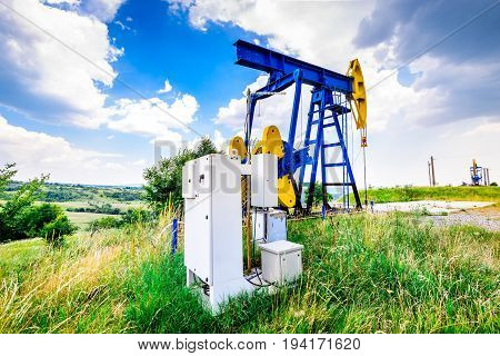 Extraction oil pumps with electrical PLC cabinet. Oil and gas industry landscape.