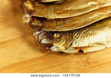 Smoked European sprats Sprattus sprattus on a wooden background.
