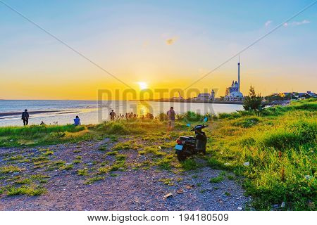 View of Tamsui from grassland seaside area during sunset