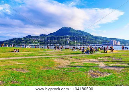 TAIPEI TAIWAN - MAY 29: View of Tamsui riverside park area where people come to sit relax and have picnic in the summer time and look at the river views on May 29 2017 in Taipei