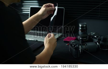 Photographer working checking film negative Stylish home studio concept of hipster . Seleted focus.