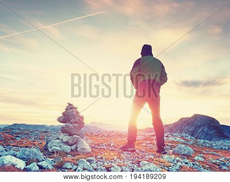 Alone Adult Man Is Stocking Stone To Pyramid.alps Mountain Summit, Evening Sun At Horizon.