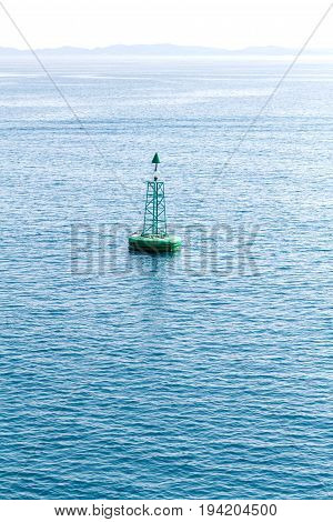 Green buoy floating in sea. Corfu island, Greece