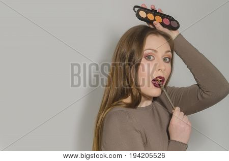Woman Applying Makeup On Pretty Face With Brush