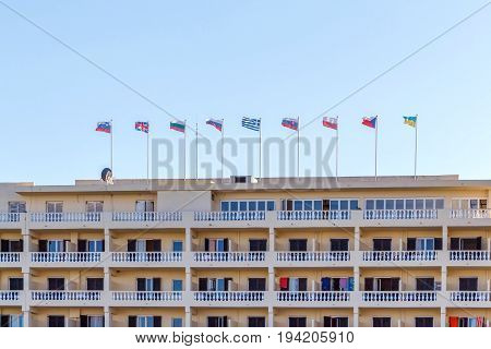 Different countries flags on hotel building. Corfu island, Greece. Daylight