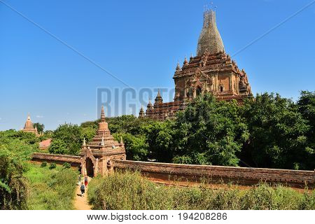 European travellers sitting on paveway along pagodas while travel in Bagan ancient city Mandalay Myanmar Asia
