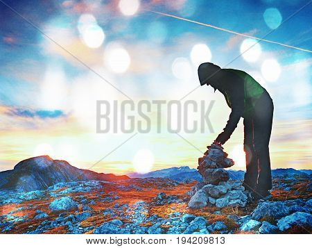 Film Grain Effect.  Alone Adult Man Is Stocking Stone To Pyramid. Alps Mountain Summit,