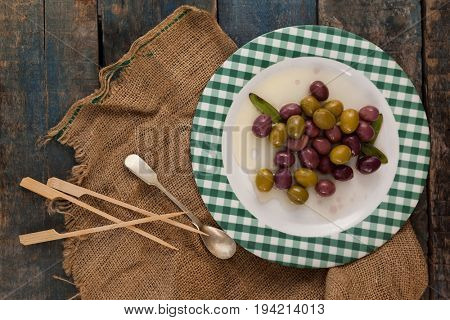 Directly above shot of olives served in plate on wooden table