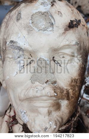 Decommunization in Ukraine. Damaged bust of Lenin in the garbage dump. Close-up.