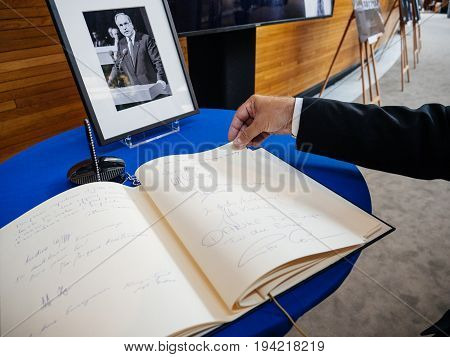STRASBOURG FRANCE - JUL 1 2017: The messages in diverse languages of high ranked officials on the book of condolences next to a portrait of late former German Chancellor Helmut Kohl at European Parliament. Kohl who was Christ democrat or CDU party member
