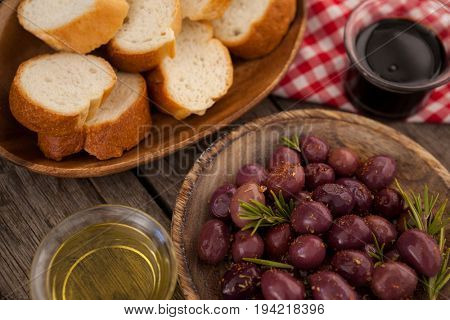 Close up of olives and bread with oil on table