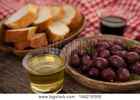 Close up of olives and bread with oil in container on table