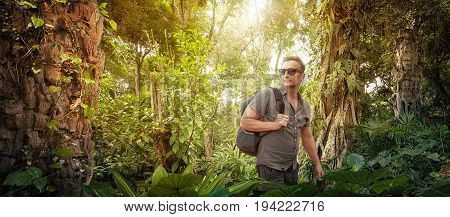 explorer- tourist with backpack studies ancient ruins in the Central America wild jungles. Concept travel and adventure.