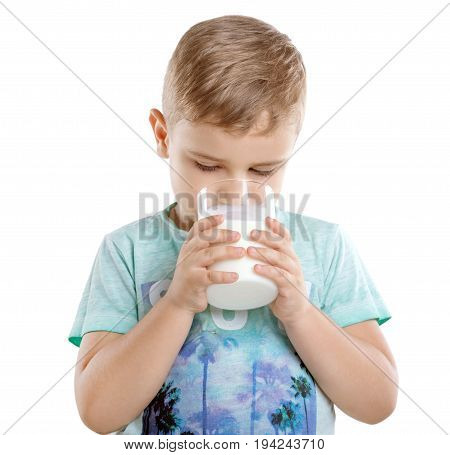 Concept of healthy food and drinks. Pretty little boy is drinking milk from a glass. Close-up portrait of cute little child is drinking milk, isolated on a white background.