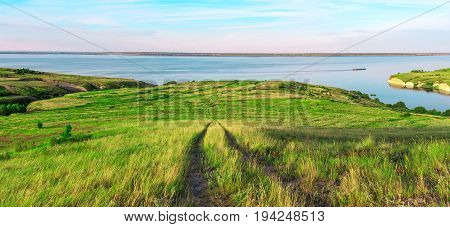 Scenic sea view from top of hills. Beautiful summer background. Amazing landscape with yellow meadows green trees blue sky steep cliffs and picturesque bay. Panoramic photo. Camping rest relax.