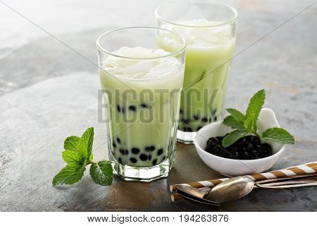 Matcha bubble tea with tapioca pearls in tall glasses