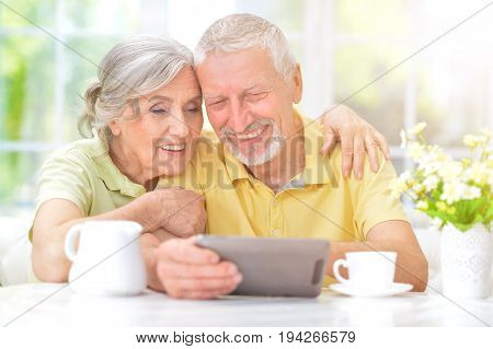 Portrait of a happy senior couple using digital tablet