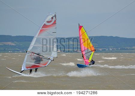 Two windsurfers on Lake Neusiedl fully in motion - Austria