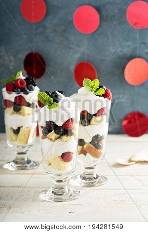 Layered dessert parfait with sweet bread, whipped cream and berries