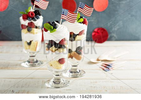 Layered dessert parfait with sweet bread, whipped cream and berries for 4th of July