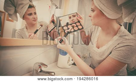Woman In Bathroom Applying Contour Bronzer On Brush