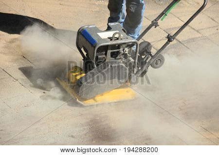 a Pavior at work using a compactor