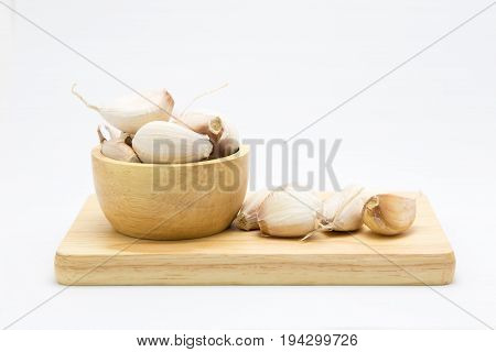 Raw garlic blub on wooden bowl on white background